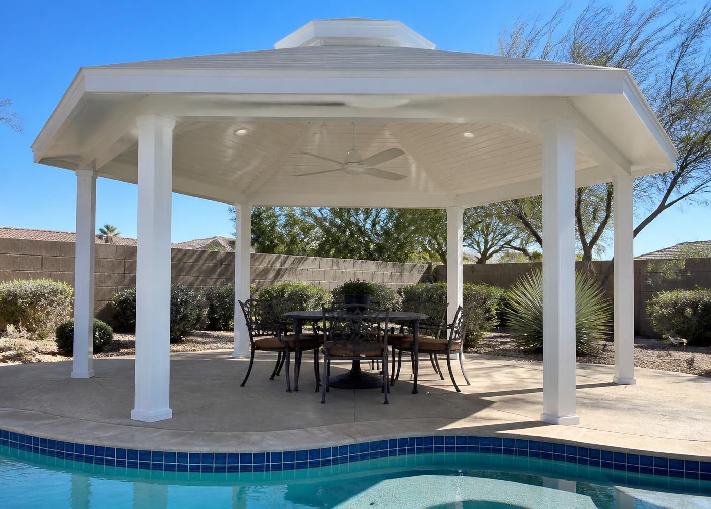 White powder coated aluminum hexagonal gazebo with a solid roof, ceiling fan and recessed lighting beside a backyard pool in Arizona